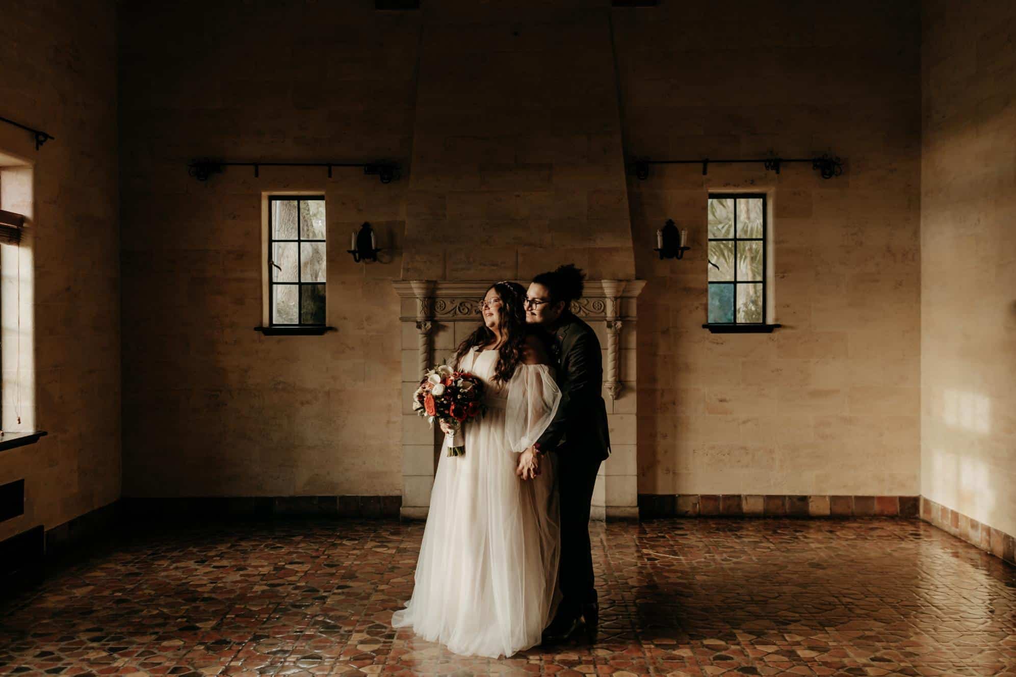 plus-size wedding gown with sheer off-the-shoulder sleeves and a flowing tulle skirt, perfect for a timeless and elegant outdoor ceremony.