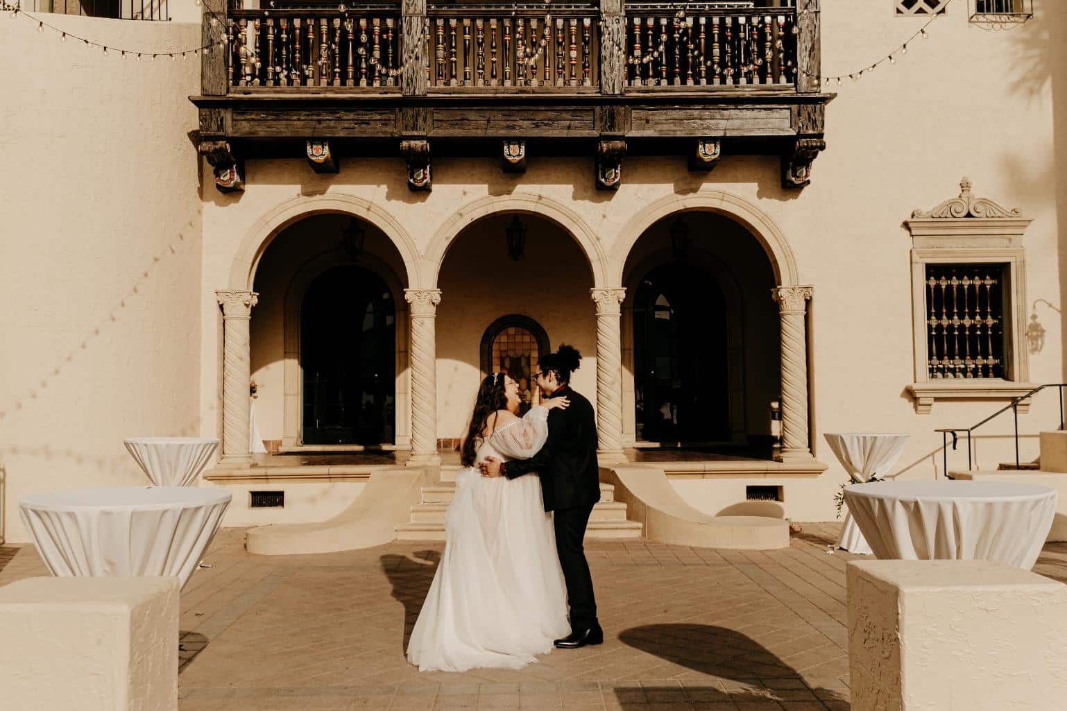 plus-size wedding gown with sheer off-the-shoulder sleeves and a flowing tulle skirt, perfect for a timeless and elegant outdoor ceremony.