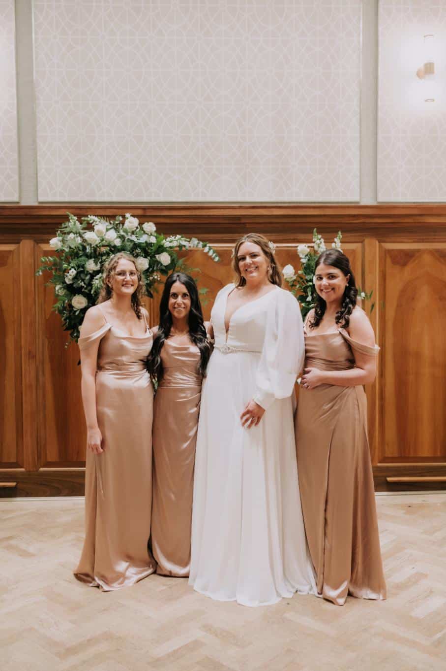 plus-size wedding gown featuring long sleeves, a plunging V-neckline, and a cinched waist with a jeweled belt, perfect for a timeless and sophisticated bridal look