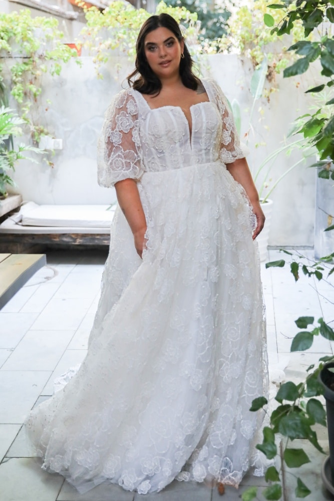 Plus-size bride in a lace wedding gown with puff sleeves and a square neckline
