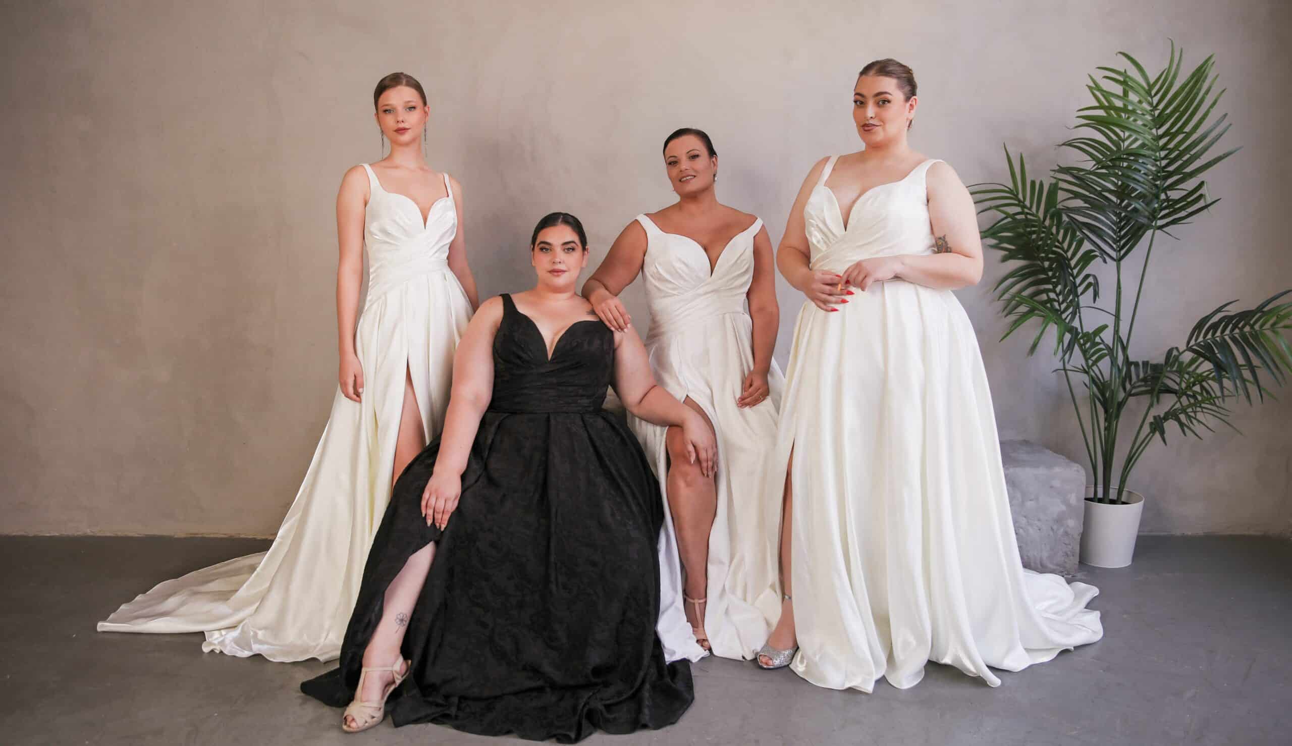 Four brides in diverse sizes model wedding gowns.