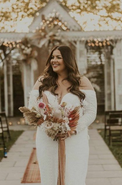 Bride in white dress with bouquet outdoors