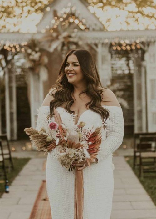 Bride in white dress with bouquet outdoors