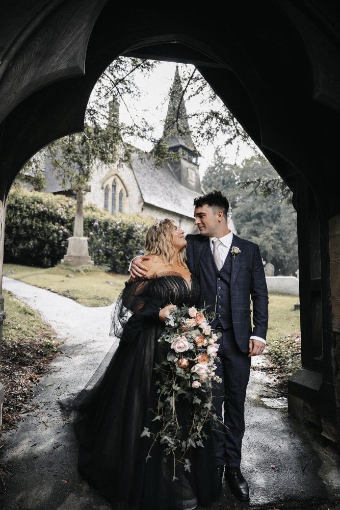 Couple in wedding attire with bouquet outdoors